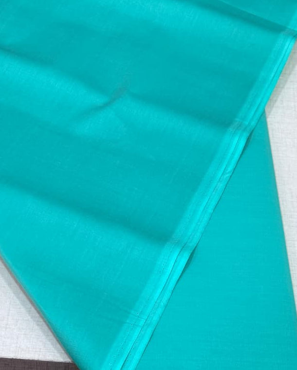 Teal fabric on a white surface with a blurred background