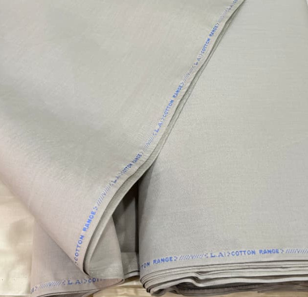 Beige fabric with a label on a table with other fabrics in the background